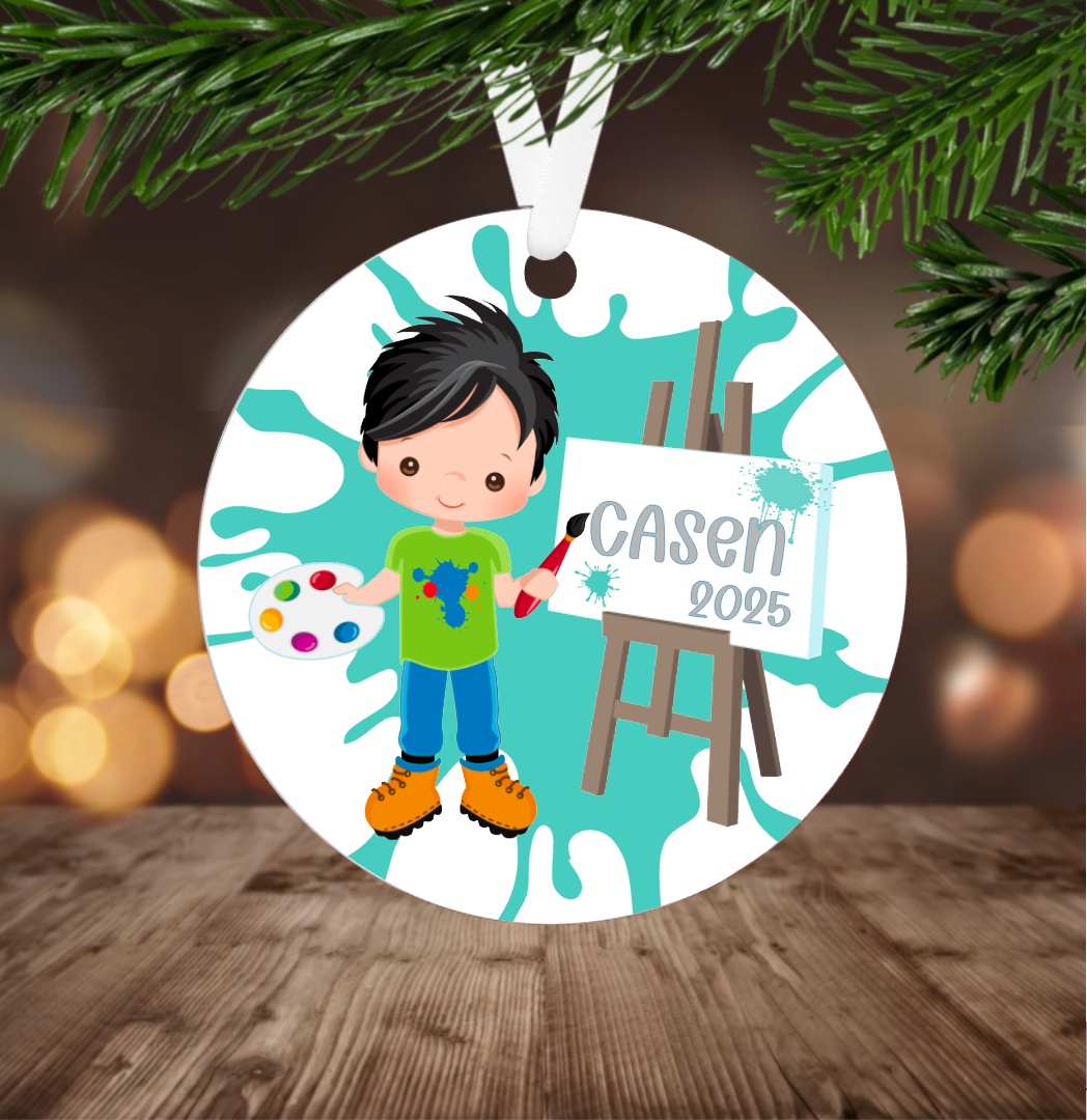 Little boy Christmas ornament with a child holding art supplies and an easel, hanging on a Christmas tree.