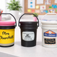 Three labeled buckets on a desk with a classroom setting in the background