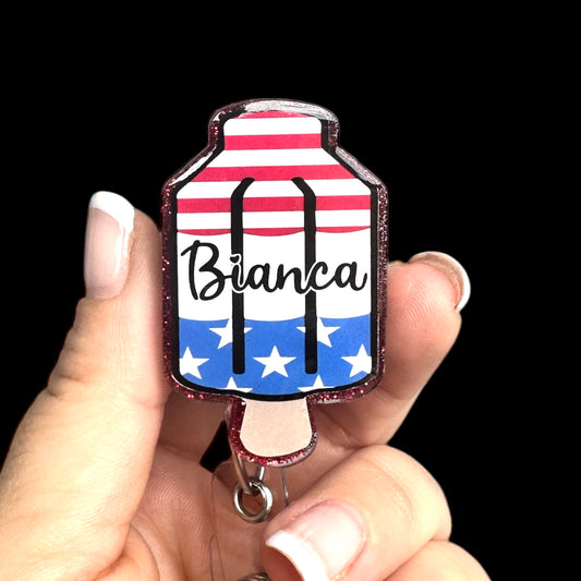 A badge reel with a popsicle design, featuring red, white, and blue colors and the name 'Bianca' printed on it.