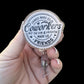 A hand holding a badge reel with a round topper that reads 'Chance Made Us Coworkers but the fun & laughter made us friends'.