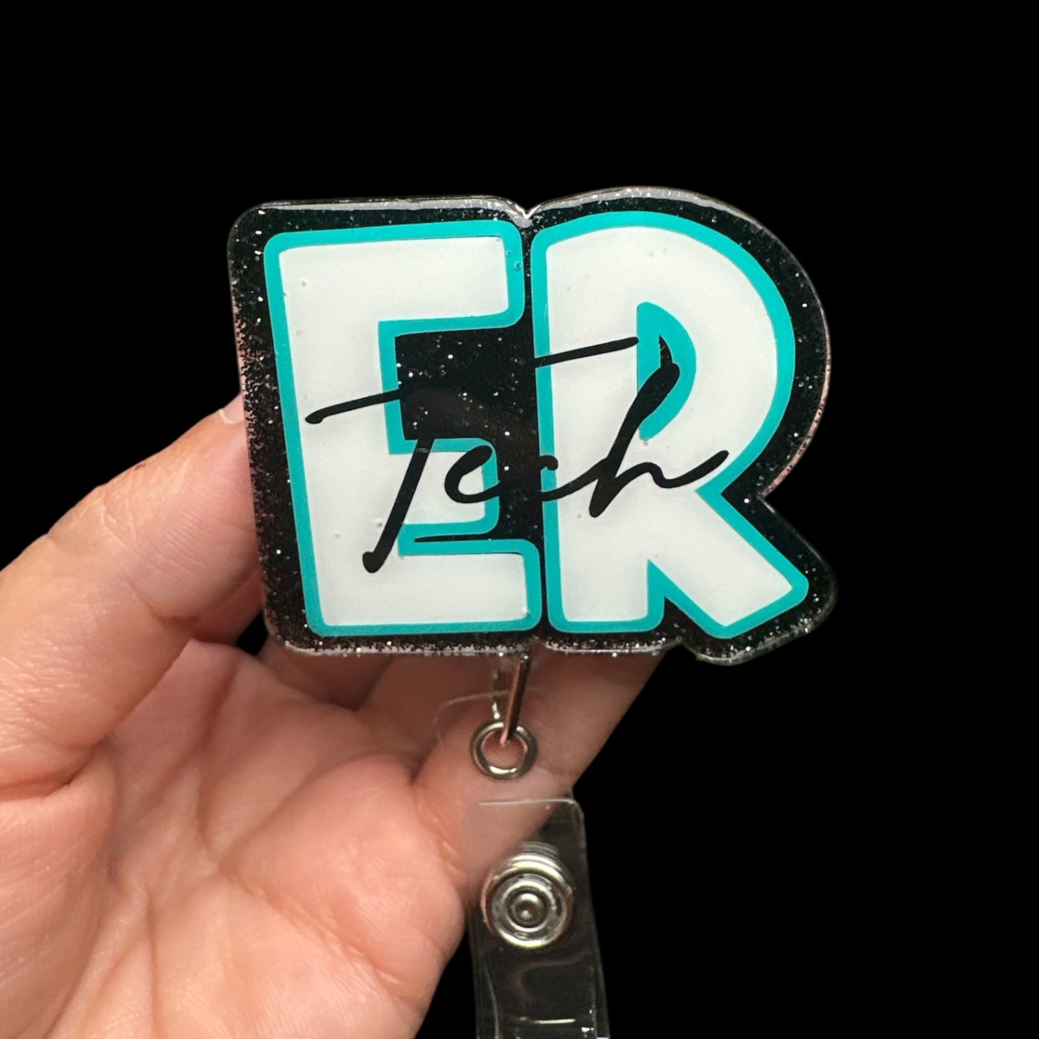 A badge reel with the text 'ER Tech' displayed in a stylized font, predominantly in black and turquoise colors