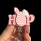 A pink badge reel with 'HOP' written on it, designed to look like a Easter egg.
