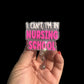 A badge reel with the phrase 'I Can't I'm in NURSING SCHOOL' written in pink and white.