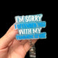 A hand holding a blue badge reel with the phrase 'I'M SORRY I OFFENDED YOU WITH MY COMMON SENSE' printed on it.