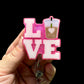 Pink glittery 'LOVE' badge holder with a drink icon 