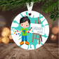 Little boy Christmas ornament with a child holding art supplies and an easel, hanging on a Christmas tree.