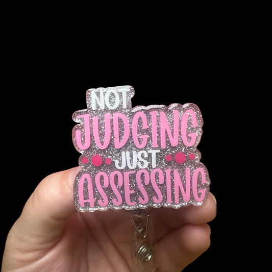 A badge reel with the phrase 'NOT JUDGING JUST ASSESSING"