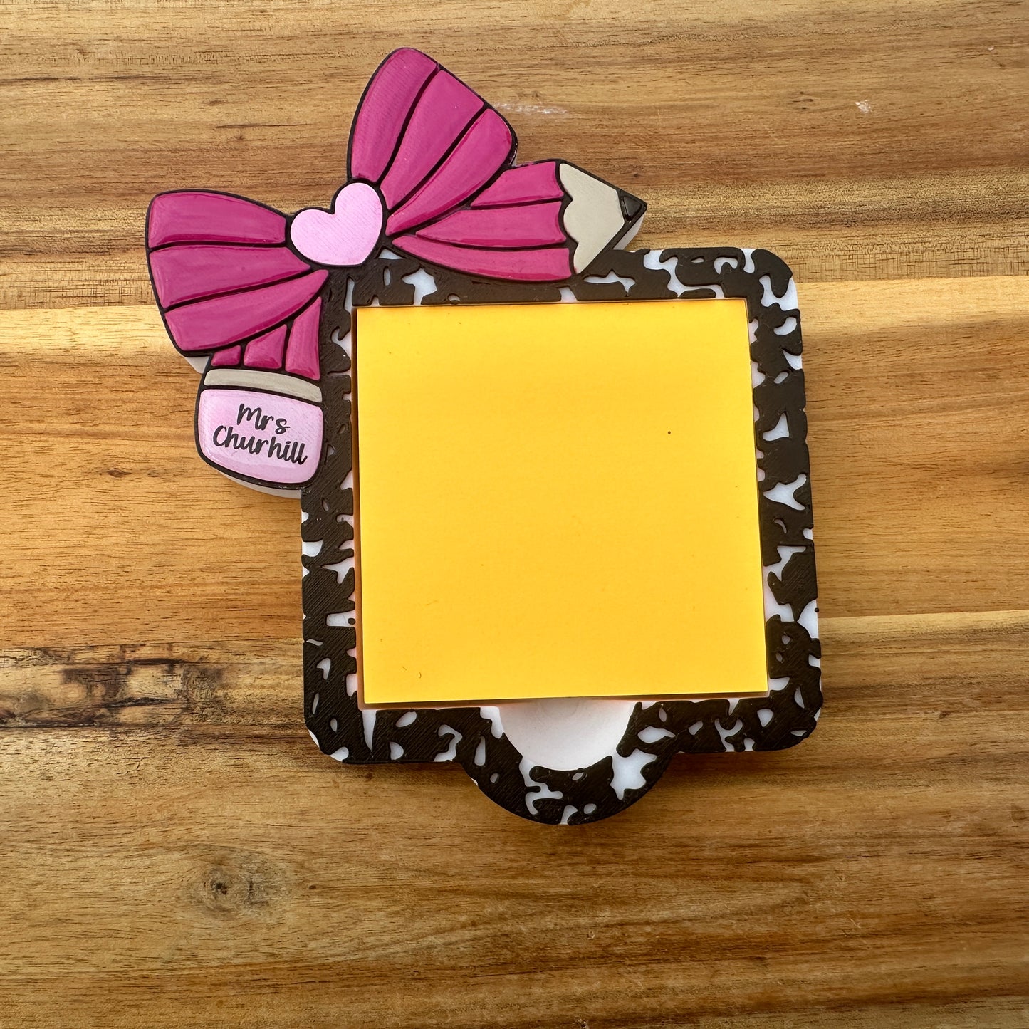 Decorative post-it note holder with a pink bow and yellow sticky note o