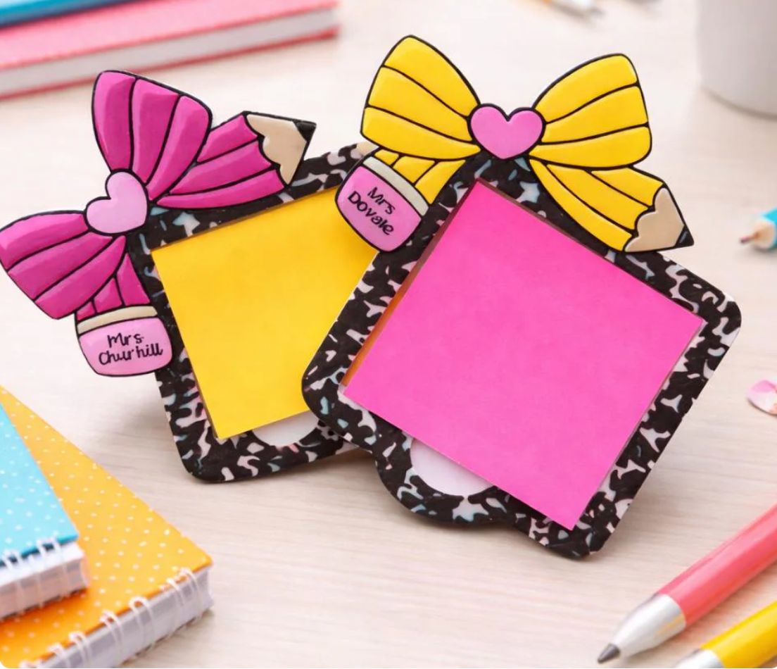 Two decorative post-it notes with colorful bows on a desk.