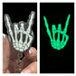 A badge reel with a skeleton hand design that glows in the dark, held in a person's hand.