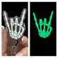 A badge reel with a skeleton hand design that glows in the dark, held in a person's hand.