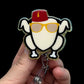 Decorative badge with cartoon character (turkey) wearing a red hat and yellow sunglasses held by a hand against a black background.