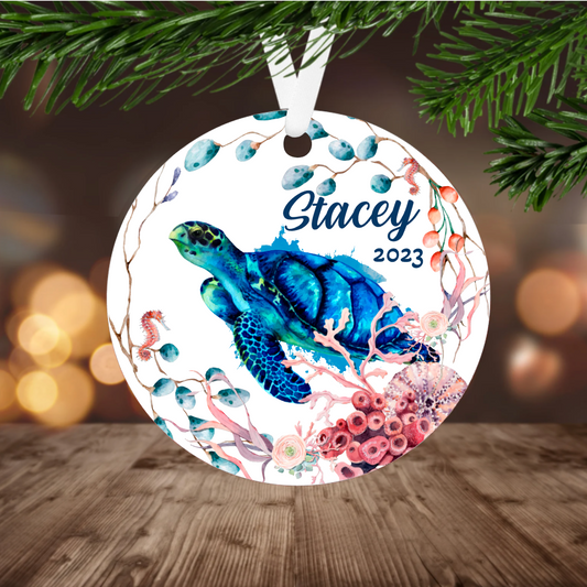 Round ornament with a blue turtle design, with name and year