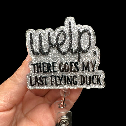 A badge reel with the phrase 'WELP, THERE GOES MY LAST FLYING DUCK' printed on it in glittery text.