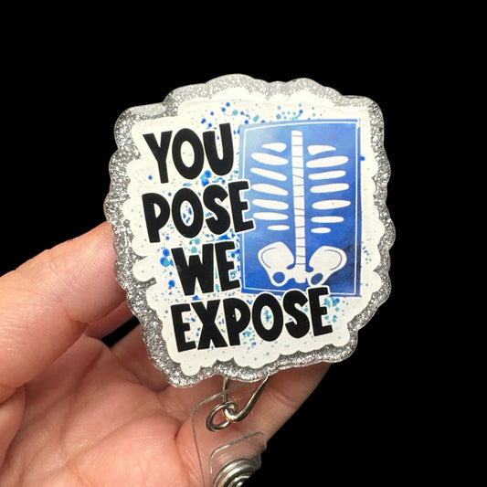 A badge reel with the text 'YOUPOSE WE EXPOSE' printed on it, featuring a blue and white color scheme