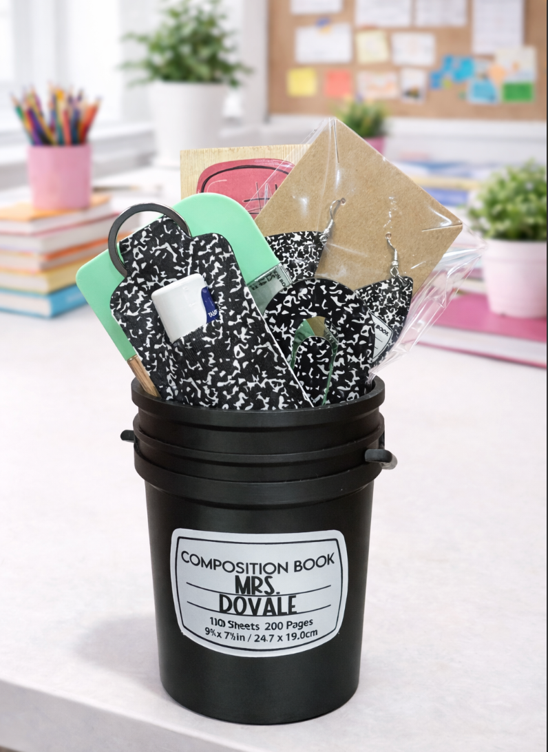 Black bucket filled with composition books and stationery items on a desk.